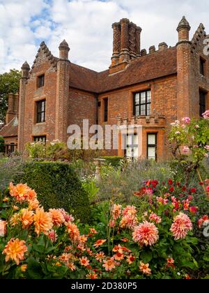 Chenies Manor Gärten im September. Chenies Manor umrahmt von pastellrosa Rose Ballerina und goldenen pfirsichfarbenen Dahlia 'Mr Frans' bei schönem Wetter. Stockfoto