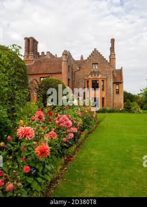 Wunderschöne Chenies Manor Gärten im September umgeben von lachsrosa Dahlien Blüten, 'Belle of Barmera', gekippten Eibenbäumen und Rosa 'Ballerina'. Stockfoto