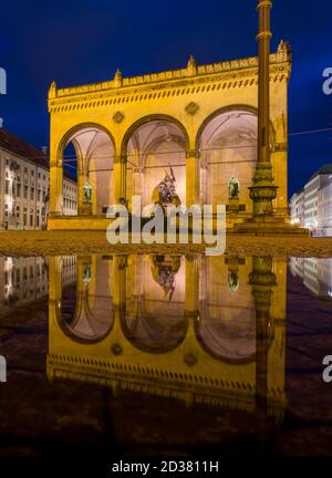 München, Deutschland. Oktober 2020. Die Feldherrnhalle am Odeonsplatz spiegelt sich in einer Wasserpfütze auf dem Boden wider. Der bayerische König Ludwig I. beauftragte den Architekten Friedrich von Gärtner mit dem Bau der Feldherrnhalle nach dem Vorbild der Loggia dei Lanzi in Florenz (Italien) in der bayerischen Hauptstadt. Die Bauzeit der bayerischen Kopie dauerte von etwa 1841 bis 1844, das Original wurde zwischen 1376 und 1382 gebaut. Kredit: Peter Kneffel/dpa/Alamy Live Nachrichten Stockfoto