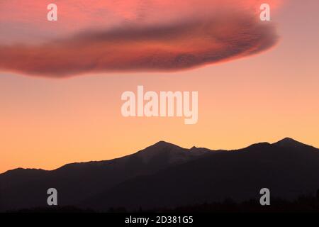 Ein romantischer Sonnenuntergang mit rosa Wolken über den italienischen Alpen Stockfoto