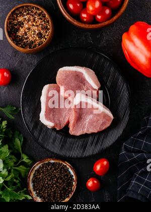 Frisches Schweinefilet auf einem schwarzen Teller Stockfoto