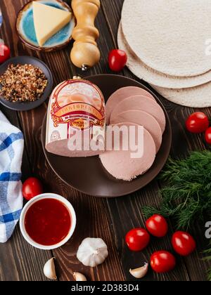 Frische hausgemachte Wurst auf dunklem Hintergrund mit Gemüse Stockfoto