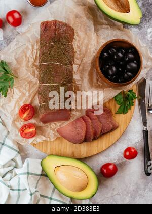 Pastrami aus Pergament mit Oliven und Avocado Stockfoto