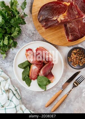 Pastrami in Scheiben geschnitten auf einem Teller mit Kräutern Stockfoto