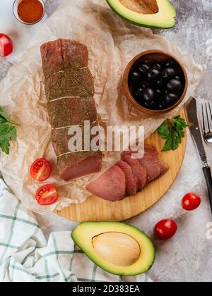 Pastrami aus Pergament mit Oliven und Avocado Stockfoto