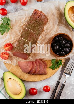 Pastrami aus Pergament mit Oliven und Avocado Stockfoto