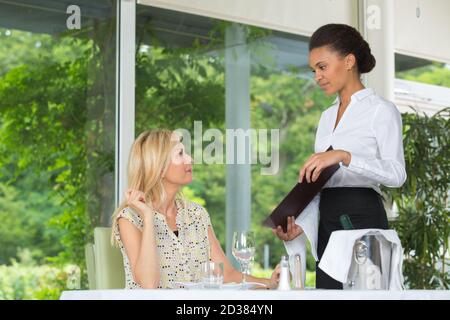 Eine Kellnerin nimmt die Bestellung auf Stockfoto