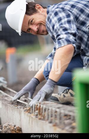 Arbeiter, der Verstärkungsstäbe auf der Baustelle anpasst Stockfoto