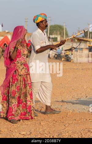 Mann und eine Frau tragen rajasthani Kleidung spielen Musikinstrument Violine am Pushkar Festival in Pushkar, Rajasthan, Indien am 19. November 2018 Stockfoto