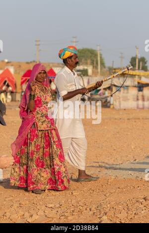 Mann und eine Frau tragen rajasthani Kleidung spielen Musikinstrument Violine am Pushkar Festival in Pushkar, Rajasthan, Indien am 19. November 2018 Stockfoto