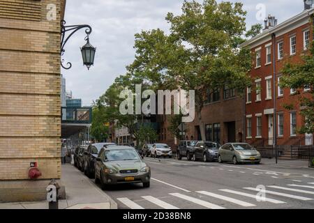 New York City, NY / USA - 7. Oktober 2020: Von Bäumen gesäumte Straße mit historischen Sandsteinhäusern im West Village Viertel in Manhattan, New Stockfoto