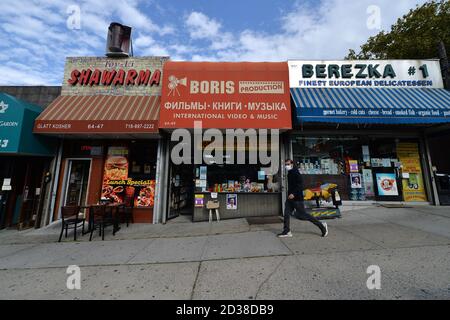 Ein Mann, der eine Maske trägt, geht am Geschäft in der ausgewiesenen „roten Zone“ des Forest Hills Viertels in Queens, NY, 7. Oktober 2020 vorbei. Gov. Andrew Cuomo hat ein dreistufiges Farbzonensystem (gelb, orange und rot) eingeführt, anstatt Postleitzahlen zu verwenden, um die Viertel zu identifizieren, die eine signifikante Spitze bei Coronavirus-Infektionen sehen, und verschiedene Einschränkungen auf der Grundlage der Farbe der Zone, rot ist die höchste. Die Beschränkungen der roten Zone umfassen maximal 10 Personen in Gotteshäusern, Gruppenversammlungen sind verboten, nur wichtige Geschäfte können geöffnet bleiben, Schulen an Stockfoto