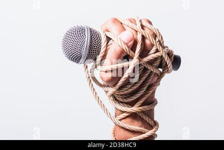 Hand mit Mikrofon und auf Faust Hand auf weißem Hintergrund geködert, Tag der Menschenrechte Konzept Stockfoto