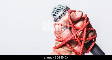 Hand mit Mikrofon und auf Faust Hand auf weißem Hintergrund geködert, Tag der Menschenrechte Konzept Stockfoto