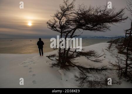 Person steht auf schneebedeckten Strand mit Blick auf das Meer Von Ochotsk Stockfoto