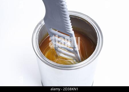 Ein Mann, der weiße Farbe in einer Dose auf weißem Hintergrund rührt. Renovierungskonzept. Stockfoto