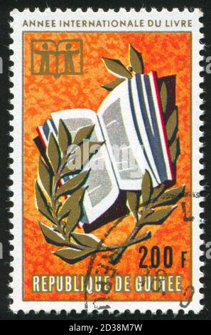 GUINEA UM 1972: Briefmarke gedruckt von Guinea, zeigt Buch und Lorbeer, um 1972 Stockfoto