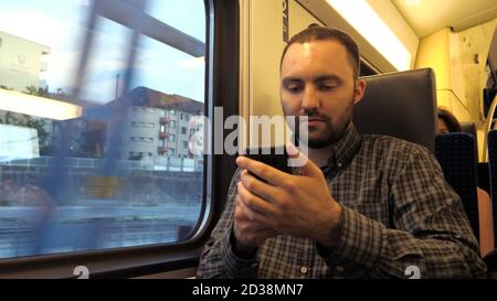 Junger Mann mit Smartphones in der U-Bahn. Stockfoto