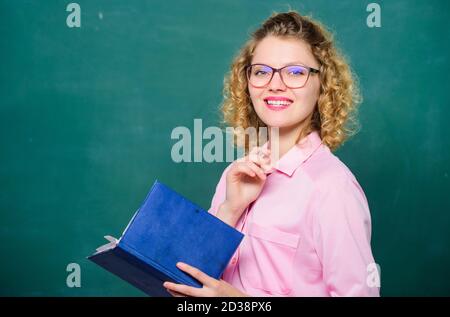 Lehrer erklären hartes Thema. Lehrer bester Freund der Lernenden. Pädagoge halten Buch und erklären Informationen. Bildungskonzept. Frau Schullehrerin vor der Tafel. Leidenschaft für Wissen. Stockfoto