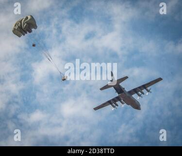 Eine C-130H Hercules, die dem 103rd Airlift Wing zugewiesen wurde, fällt während eines Five-Ship Formationsfluges in der Fallzone der Westover Air Reserve Base in Chicopee, Massachusetts, 4. Oktober 2020, eine schwere Frachtpalette ab. Die Mission, bekannt als „Max Fly“, fordert das Gerät heraus, die maximale Anzahl von Flugzeugen in seiner Flotte in einer einzigen Mission zu fliegen, und stellt eine umfassende Darstellung der Einsatzbereitschaft und der taktischen Luftlift-Fähigkeiten des Geräts dar. (USA Foto der Air National Guard von Staff Sgt. Steven Tucker) Stockfoto