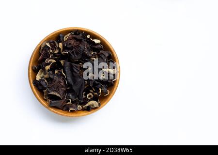 Getrockneter schwarzer Pilz in Holzschale auf weißem Hintergrund. Stockfoto