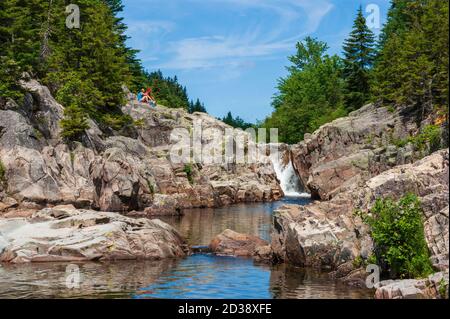 Wanderpaar auf einer Klippe über dem Broad River. Wasserfälle und Pools entlang des Baches. Moosehorn Trail, Fundy National Park, New Brunswick, Kanada Stockfoto