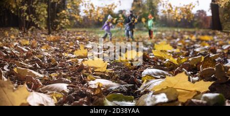 Kinder spielen im Herbstpark, verschwommene Silhouetten Stockfoto