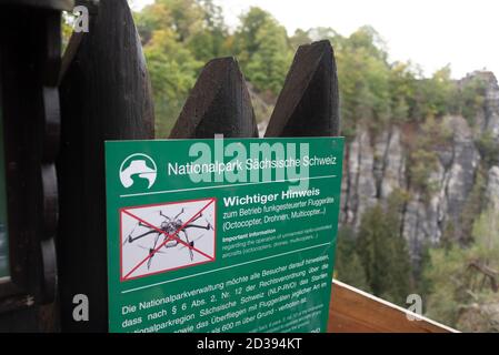 Bastei, Deutschland. Oktober 2020. An der Bastei-Brücke dürfen keine Drohnen gestartet werden. Die Nationalparkverwaltung Sächsische Schweiz weist darauf mit Schildern hin. Dennoch fliegen immer wieder kleine Drohnen über die Bastei-Brücke. Die Hobbypiloten müssen mit hohen Geldstrafen rechnen, wenn sie gefangen werden. Quelle: Stephan Schulz/dpa-Zentralbild/ZB/dpa/Alamy Live News Stockfoto