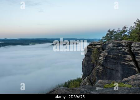 Hohnstein, Deutschland. Oktober 2020. Dichte Nebelschwaden umhüllen die Festung Königstein. Davor sind die Felsen des Liliensteins zu sehen. Von hier aus haben Sie einen Panoramablick über das Elbsandsteingebirge. Quelle: Stephan Schulz/dpa-Zentralbild/ZB/dpa/Alamy Live News Stockfoto