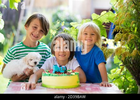 Kleinkind Junge, feiert seinen Geburtstag mit Brüdern und Familie im Garten Stockfoto