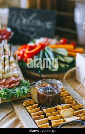 Hausgemachte dunkle Sauce in einem Glas ist auf Croutons auf dem Tisch mit Snacks. Wunderschön dekorierter Catering-Banketttisch mit verschiedenen Snacks und Snacks Stockfoto