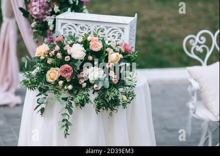 Schöne florale Details der Hochzeitszeremonie im Freien. Nahaufnahme von Blumensträußen und Arrangements in rosa. Hochzeitszeremonie auf grünem Rasen in der gar Stockfoto