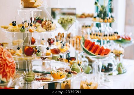 Verschiedene frische Früchte auf dem Hochzeitstisch. Tischdekoration für Hochzeiten. Obstbuffet am Empfang. Hochzeitsempfang Catering-Tisch mit verschiedenen fru Stockfoto