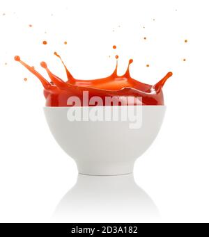Tomatensuppe spritzt aus einer Schüssel isoliert auf weiß Stockfoto