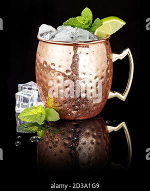 Frostiger Moscow Mule in einem Kupferbecher isoliert auf schwarz Hintergrund Stockfoto