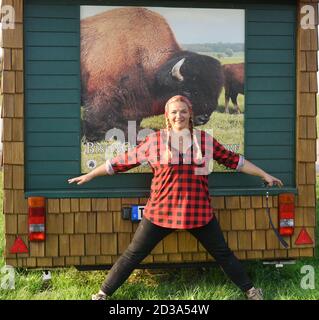 01. Oktober 2020, Sachsen, Wermsdorf: Cora Lechner steht mit ihrem Lebenspartner Johannes Boos und den Kindern Nils (5, l) und Lukas (9) an der Hand, die fünf Monate altes Bison-Kalb 'Hannes' großgezogen haben. Anfang des Jahres übernahm die junge Frau eine Herde von 60 Bisons, die ihr Vater 2003 gründete. Gemeinsam mit ihrem Lebenspartner Johannes Boos betreut sie die Zucht und ökologische Haltung der Wildrinder, die in Nordamerika weit verbreitet sind. Sie finden auf 40 Hektar frisches Weidegras und erhalten Bio-Heu als Ergänzungsfutter. Das Fleisch der Pflanzenfresser, w Stockfoto