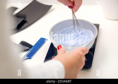 Coiffeur ist Mischen Farbstoff in weißen Schüssel für Haarfärbung In ihren Händen Stockfoto