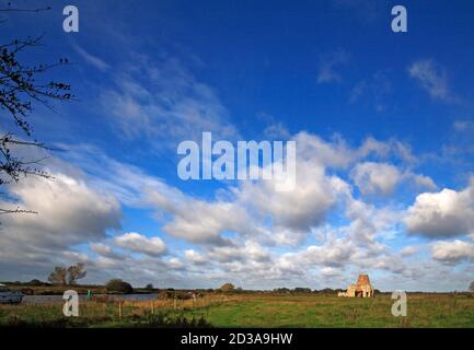 Ein Blick auf das zerstörte Torhaus von St Benet's Abbey und Windmühle am Fluss Bure auf den Norfolk Broads in Horning, Norfolk, England, Vereinigtes Königreich. Stockfoto