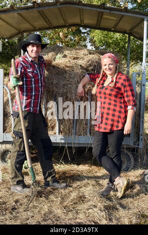 01. Oktober 2020, Sachsen, Wermsdorf: Cora Lechner steht mit ihrem Lebenspartner Johannes Boos in ihrem Bisongehege an einem Lagerplatz für Bio-Heu. Die junge Frau übernahm Anfang des Jahres eine Herde von 60 Bisons, die ihr Vater 2003 gründete. Gemeinsam mit ihrem Lebenspartner Johannes Boos betreut sie die Zucht und ökologische Haltung der Wildrinder, die in Nordamerika weit verbreitet sind. Sie finden auf 40 Hektar frisches Weidegras und erhalten Bio-Heu als Ergänzungsfutter. Das Fleisch der bis zu 900 Kilogramm schweren Pflanzenfresser wird in ihrem Hofladen als fre verkauft Stockfoto