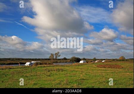 Ein Blick auf Kreuzer auf dem Fluss Bure auf den Norfolk Broads vorbei an der Stelle der St. Benet's Abbey im Herbst in Horning, Norfolk, England, Großbritannien. Stockfoto