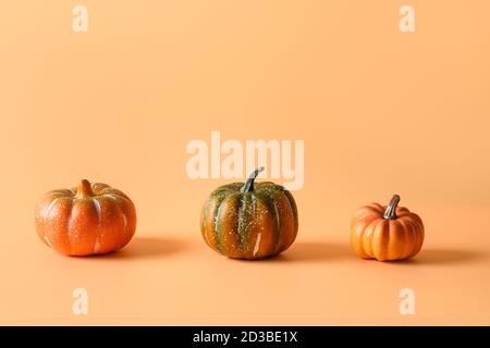 Thanksgiving Tag oder Halloween verschiedene drei Kürbisse auf orangefarbenem Hintergrund. Platz für Text oder Design. Stockfoto