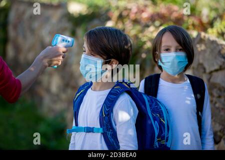 Lehrer oder medizinische Person, Kontrolle der Temperatur und tun medizinische Kontrolle in der Schule für covid 19 Stockfoto