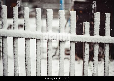 Alte Holzzaun mit Schnee bedeckt. Das kaputte Teil. Stockfoto