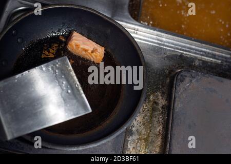 Ein Stück roter Fisch in einer schwarzen Pfanne. Stockfoto