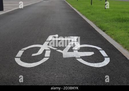 Weiß gezeichnetes Fahrradschild auf dem Asphalt. Separater Radweg für Radfahrer, umweltfreundlicher Stadtverkehr für Sport . Dnepropetrovsk, Dnipro Stockfoto