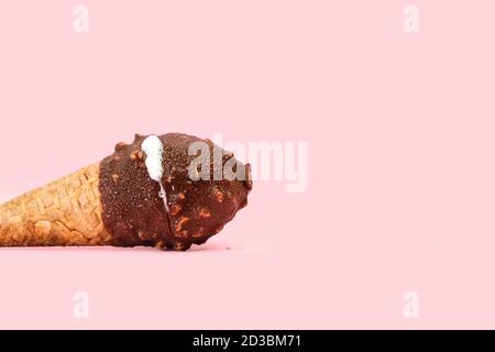 Schokolade Eis-Kegel mit Erdnüssen Chips auf einem rosa Hintergrund Stockfoto