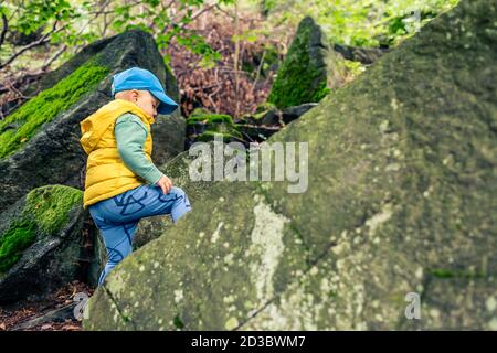 Kleiner Junge Wandern und Klettern in den Bergen, Familienabenteuer. Kleines Kind zu Fuß in felsigen grünen Wald. Stockfoto