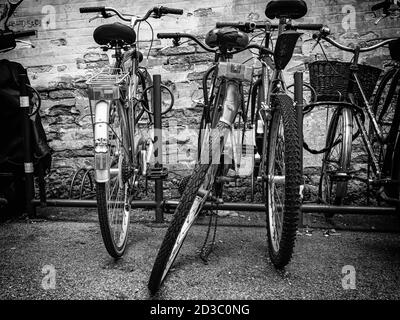 Gebrochenes Fahrrad in einem Fahrradständer abgelegt (Der Text an der Wand sagt ' samstagabend' ) Stockfoto