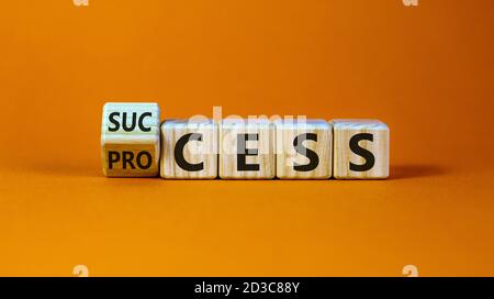 Einen Würfel gedreht und den Ausdruck 'Erfolg' in 'Prozess' geändert. Schöner orangefarbener Hintergrund. Geschäftskonzept. Speicherplatz kopieren. Stockfoto
