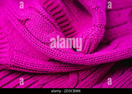 Magentafarbener Hintergrund. Vollformataufnahme aus Strickmaterial Stockfoto
